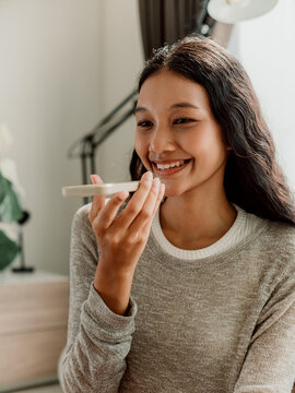 Happy Woman Using Smartphone Voice Assistant at Home
