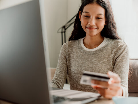 Smiling Woman Shopping Online with Laptop and Credit Card
