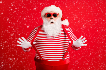 Portrait of his he nice handsome attractive comic childish amazed grey-haired Santa having fun pulling suspenders festal look outfit isolated over bright vivid shine vibrant red color background