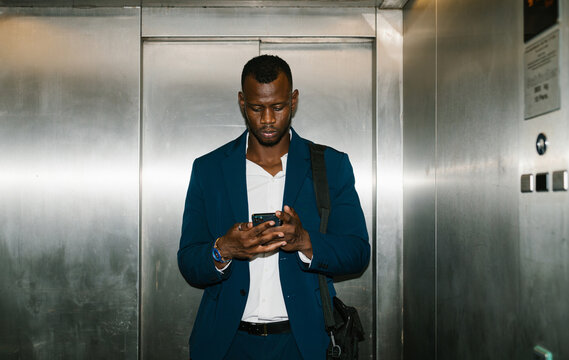 Businessman checking phone in elevator