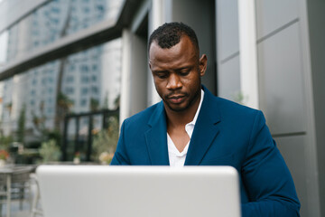Businessman working on laptop in modern outdoor setting