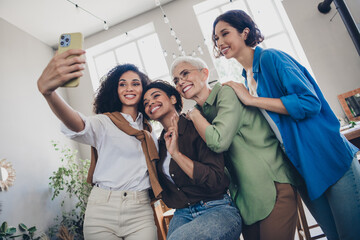 Photo of four diverse women businessladies feminists community take selfie photo comfortable modern office room interior indoors workspace