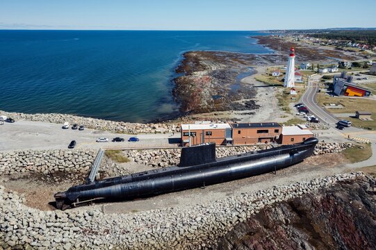 The HMCS Onondaga (S73) Submarine on display,. Behind is the Lieu historique national du phare de Pointe-au-P&egrave;re, Lighthouse. Rimouski, Quebec, Canada.
