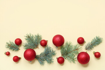 Beautiful composition with Christmas balls and fir branches on beige background