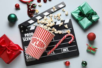Bucket of popcorn, movie clapper, candy cane and Christmas decor on white background