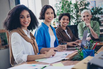 Photo of corporate four colleagues women feminists supportive community leadership meeting coworking successful nice light office