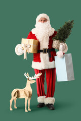 Santa Claus with shopping bag, Christmas tree, gift box and wooden deer on green background