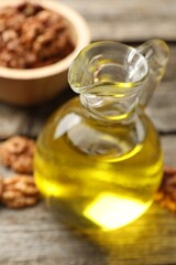 Cooking oil in jug on wooden table, closeup