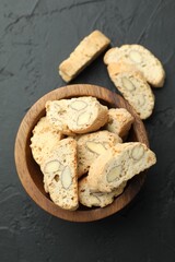 Traditional Italian almond biscuits (Cantucci) in bowl on black table, top view