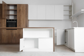 Interior of light kitchen with table and open drawers