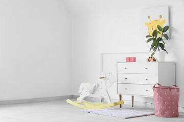 Chest of drawers, rocking horse and toys in light nursery