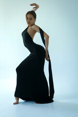 curves of the body of a young woman in a long black evening dress, the beauty of the female body