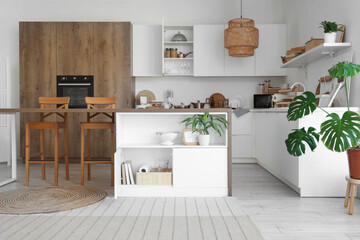 Interior of modern kitchen with table, counters and cupboards