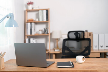 Wooden work desk with laptop and documents,  modern interior of cozy cabinet, table for working at home, comfortable workspace, workplace