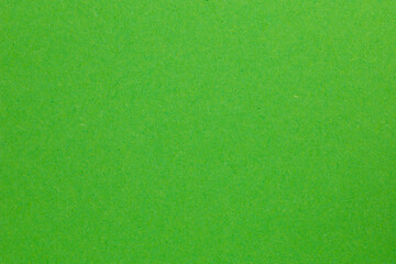 A green field with grass and a few small patches of dirt, textured origami paper backdrop