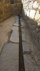 Obraz premium Water drainage canal at Ollantaytambo ancient Inca fortress village