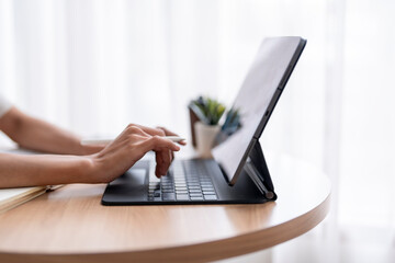 Businesswoman working from home using tablet with keyboard