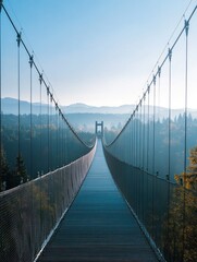 Fototapeta premium A serene suspension bridge stretches over a misty landscape, connecting nature and adventure.