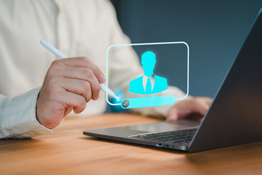 Close-up of a person using a pen to interact with a virtual profile icon on a laptop, representing digital identity verification, login process, or online access authorization. - Powered by Adobe