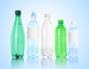 Different plastic bottles with water on light blue background