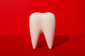 A large, voluminous tooth on a red background.