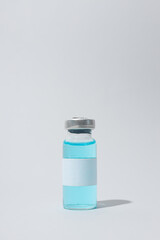 Glass medical bottle with vaccine on light background