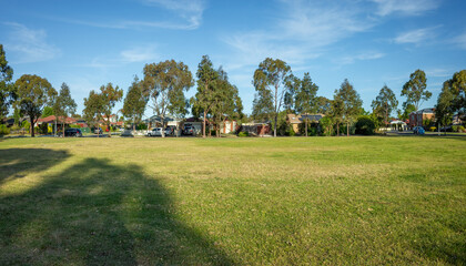 Panoramic view of an Australian suburban park or recreational reserve featuring a wide open well-maintained grass field bordered by tall eucalyptus trees. Hoppers Crossing, Melbourne