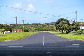 Expansive, low-density suburban landscape of Warrnambool, Australia. The wide, empty road leads to...