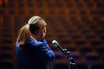 Sad Businesswoman Feeling Overwhelmed about Speaking in public. Fearful shy woman having problems with her discourse on a stage 