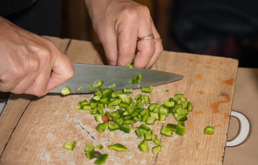 finely cutting the peppers on a wooden bell