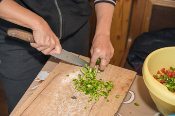 finely cutting the peppers on a wooden bell