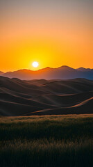 A breathtaking sunrise over rolling hills and a field of grass.