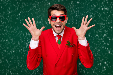 Naklejka premium Photo of cool impressed santa claus guy dressed red jacket glasses rising arms isolated green color background