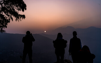 silhouette of people watching sunrise on the Mountain in Bandipur, Nepal. 