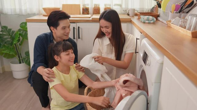 Asian family put dirty clothes to washing machine in house together.