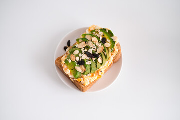 Avocado sandwich with scrambled eggs, sliced avocado and egg on toasted bread for healthy breakfast or snack.