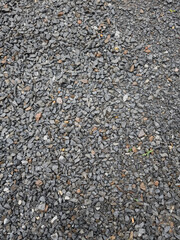 Gray small rocks ground texture. black small road stone background. gravel pebbles stone seamless texture. dark background of crushed granite gravel, close up.