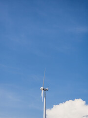 Close-up wind turbines or wind energy converter in sunny day with blue sky.