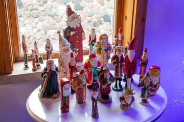 Close up view of a small side table decorated with an assortment of various vintage Christmas Santa...