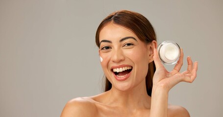 Portrait, smile and woman with cream, shine and dermatology on gray studio background. Person, happy model and girl with skincare, cosmetics and container for creme, healthy skin and grooming routine