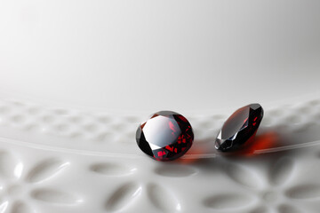  deep red garnet crystal on white plate.