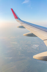 Obraz premium View from the airplane window at a beautiful cloudy sky and the airplane wing