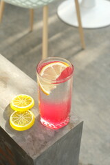 refreshing lomon squash drink during the day, with a background of wooden tables and chairs in one of the cafes