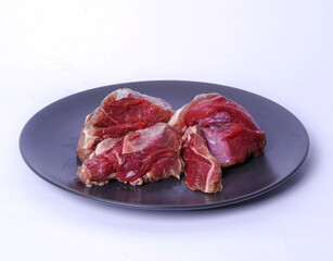 side view fresh raw beef on black plate