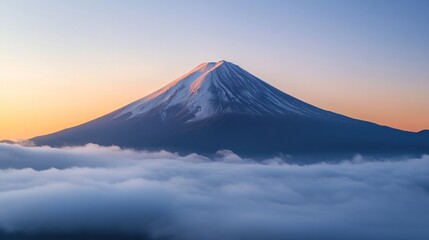 Fototapeta premium Majestic view of a snow-capped mountain peak above clouds during sunrise.