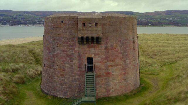 Aerial pullback and ascent from Magilligan Martello Tower, revealing Lough Foyle and the scenic Donegal landscape
