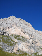 landscape in the mountains, Blue skies on a summers day in Europe Alpine region. Rocky cliff face.