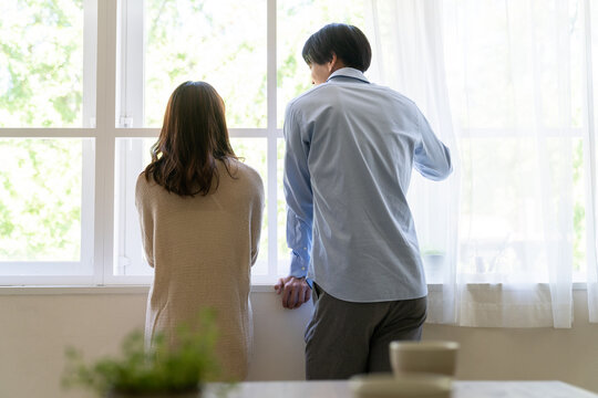 外を眺める男女の背中