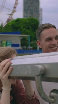 vertical chot. Couple laughing near the sea,Vertical video, daytime. man pointing to the distance