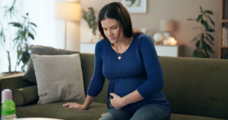 Stomach pain, health and labor with pregnant woman on sofa for stress, emergency and cramps....